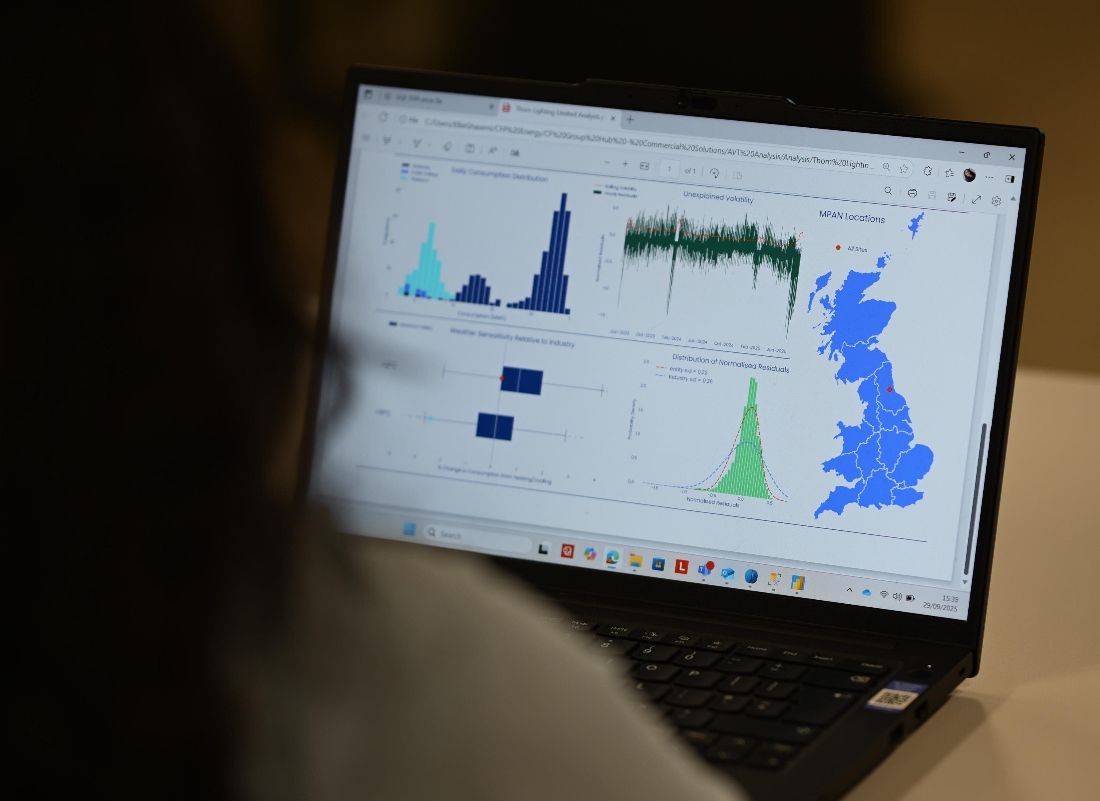 A person looks at a laptop screen showing energy data.