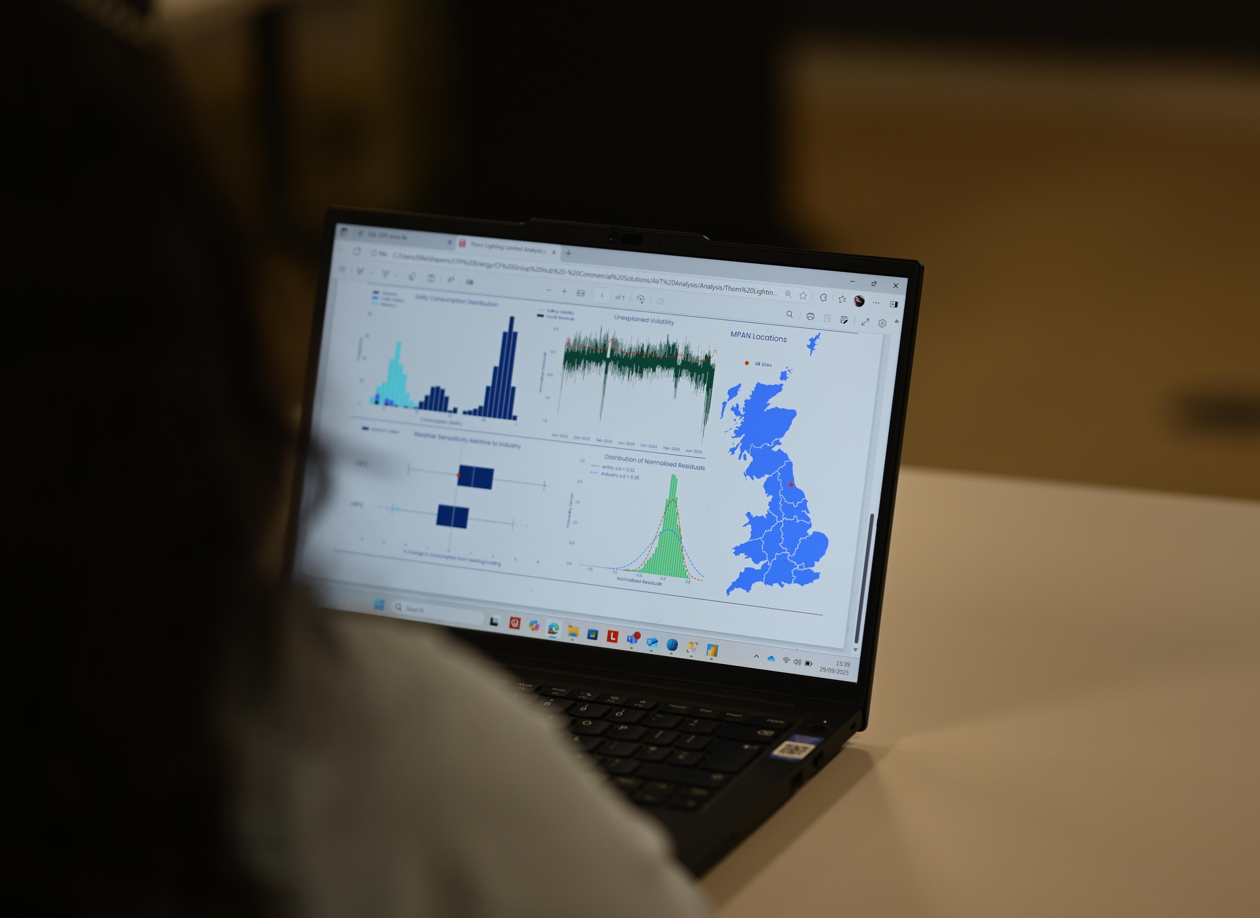 A person looking at a laptop screen that shows energy data.