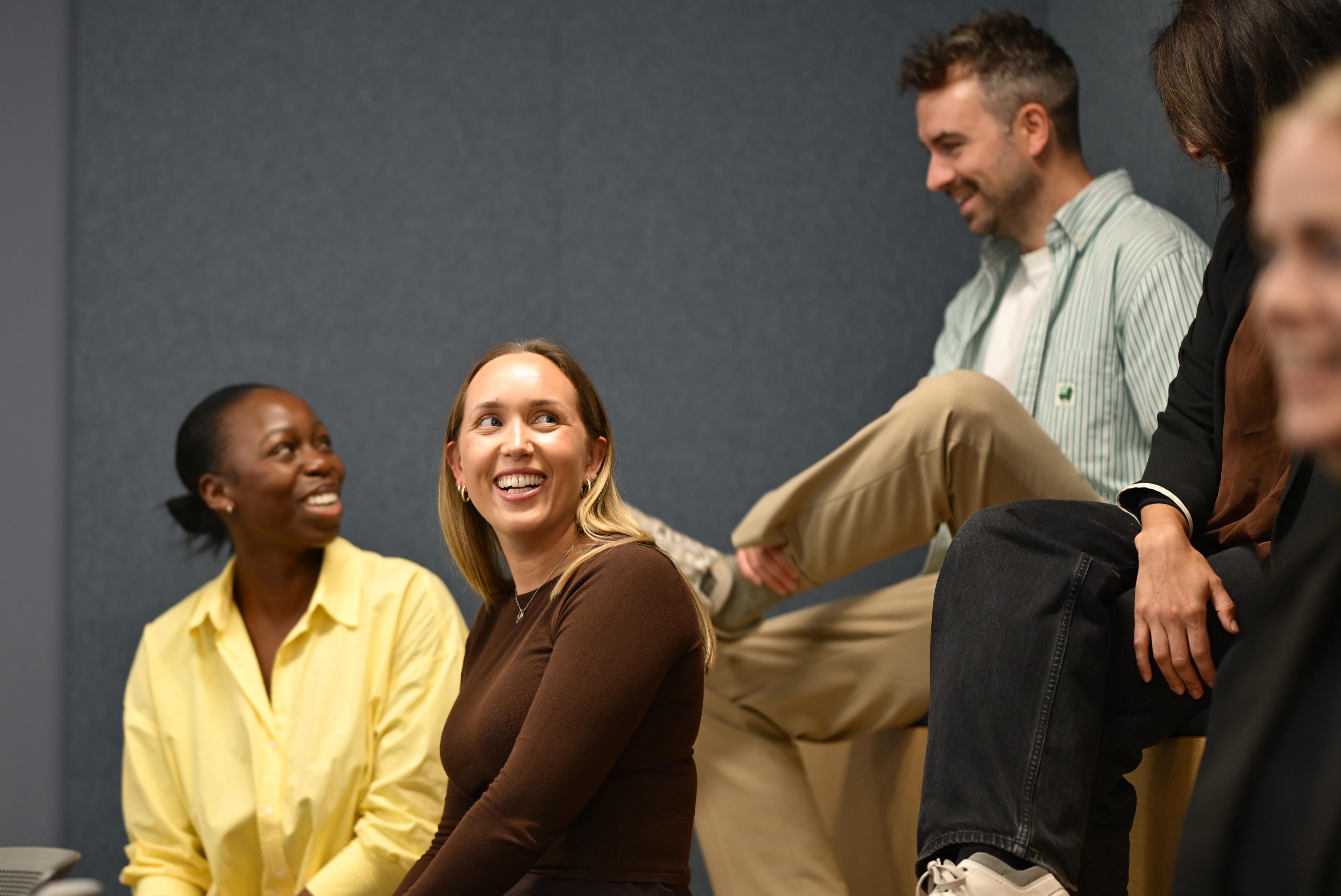 People talk and laugh in a meeting room.