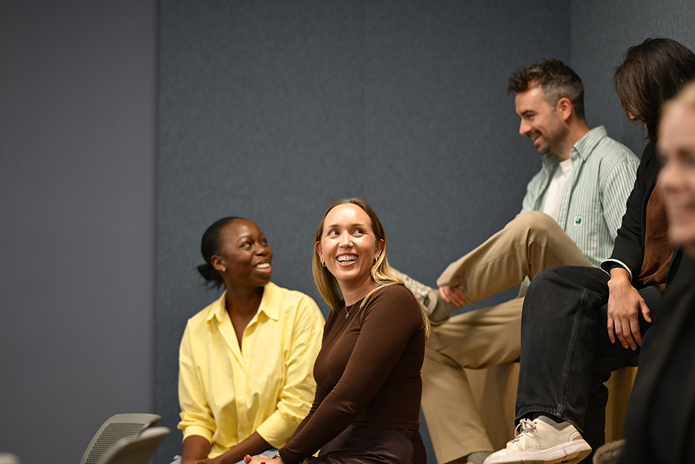 People talk and laugh in a meeting room.
