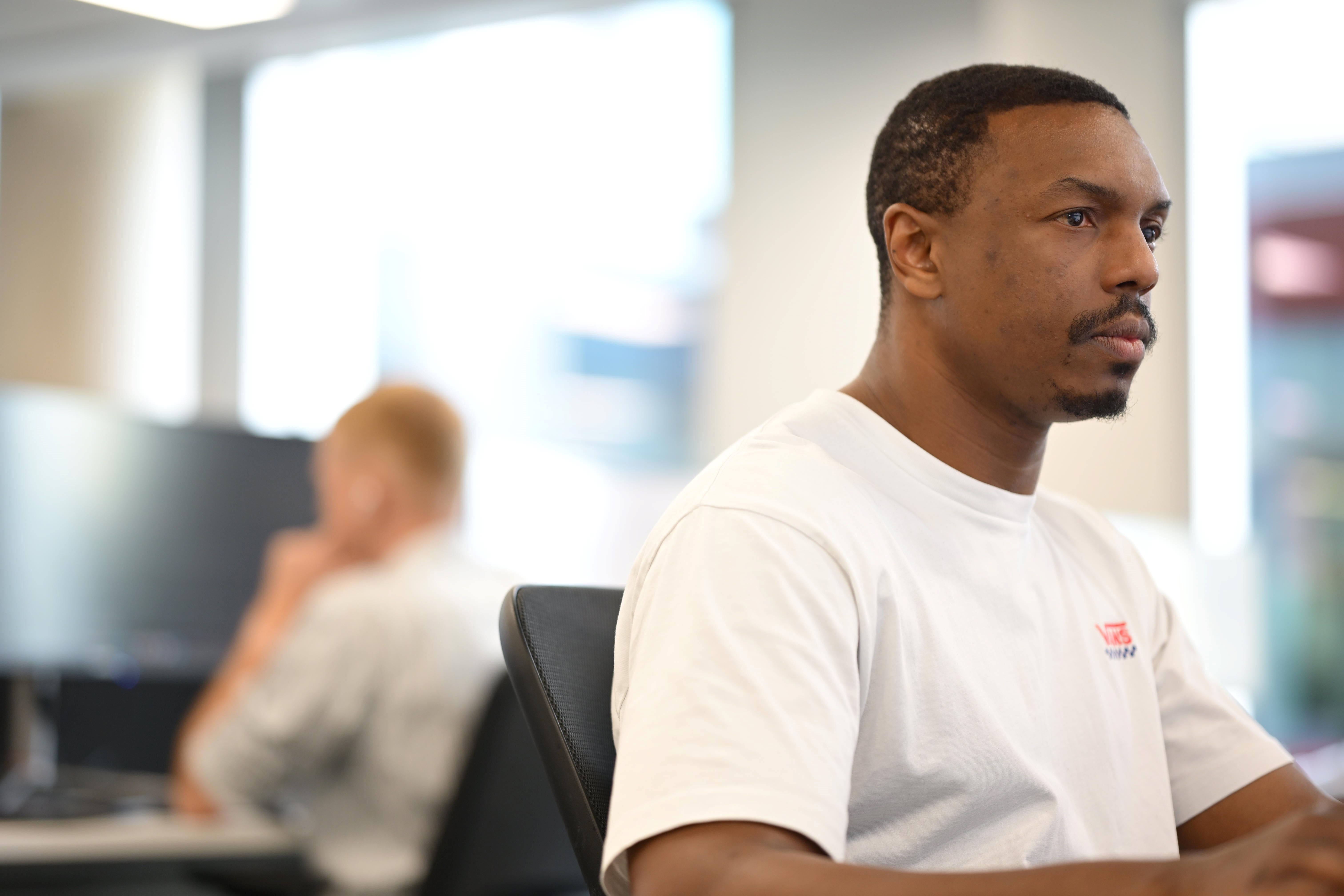 A person sits at their desk while they look at a screen.