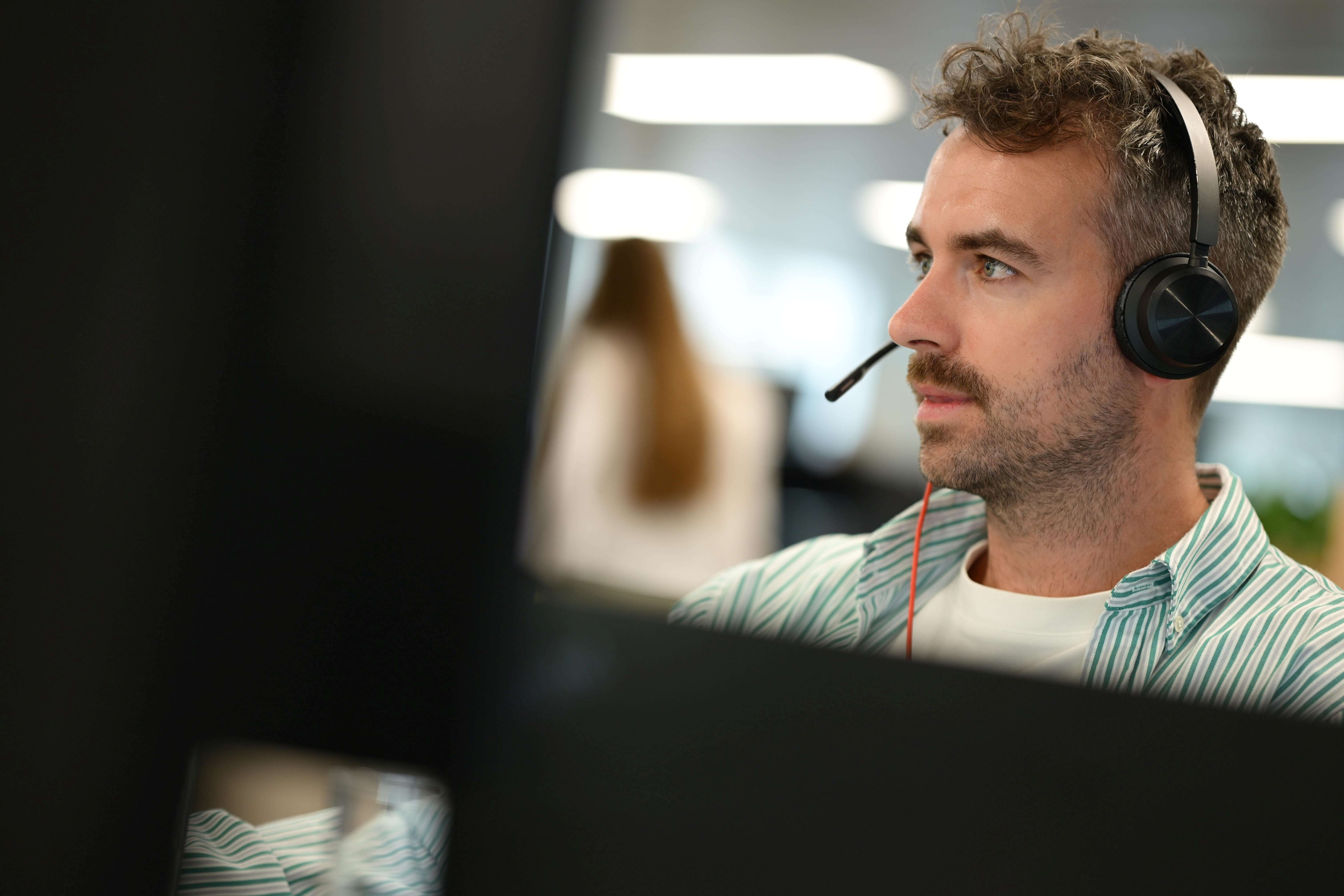 A person sat at a desk with a headset.