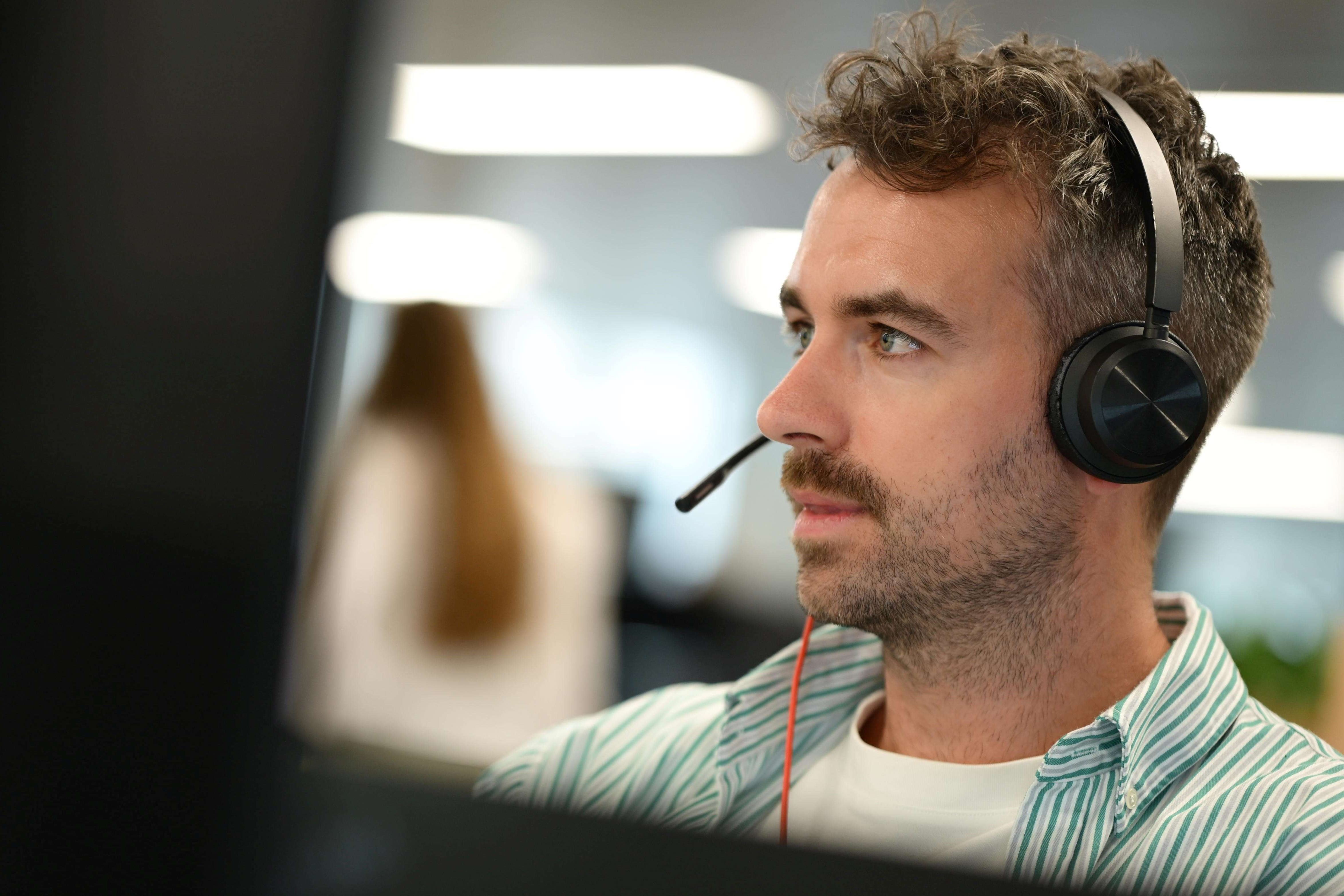 A person sat at a desk with a headset.