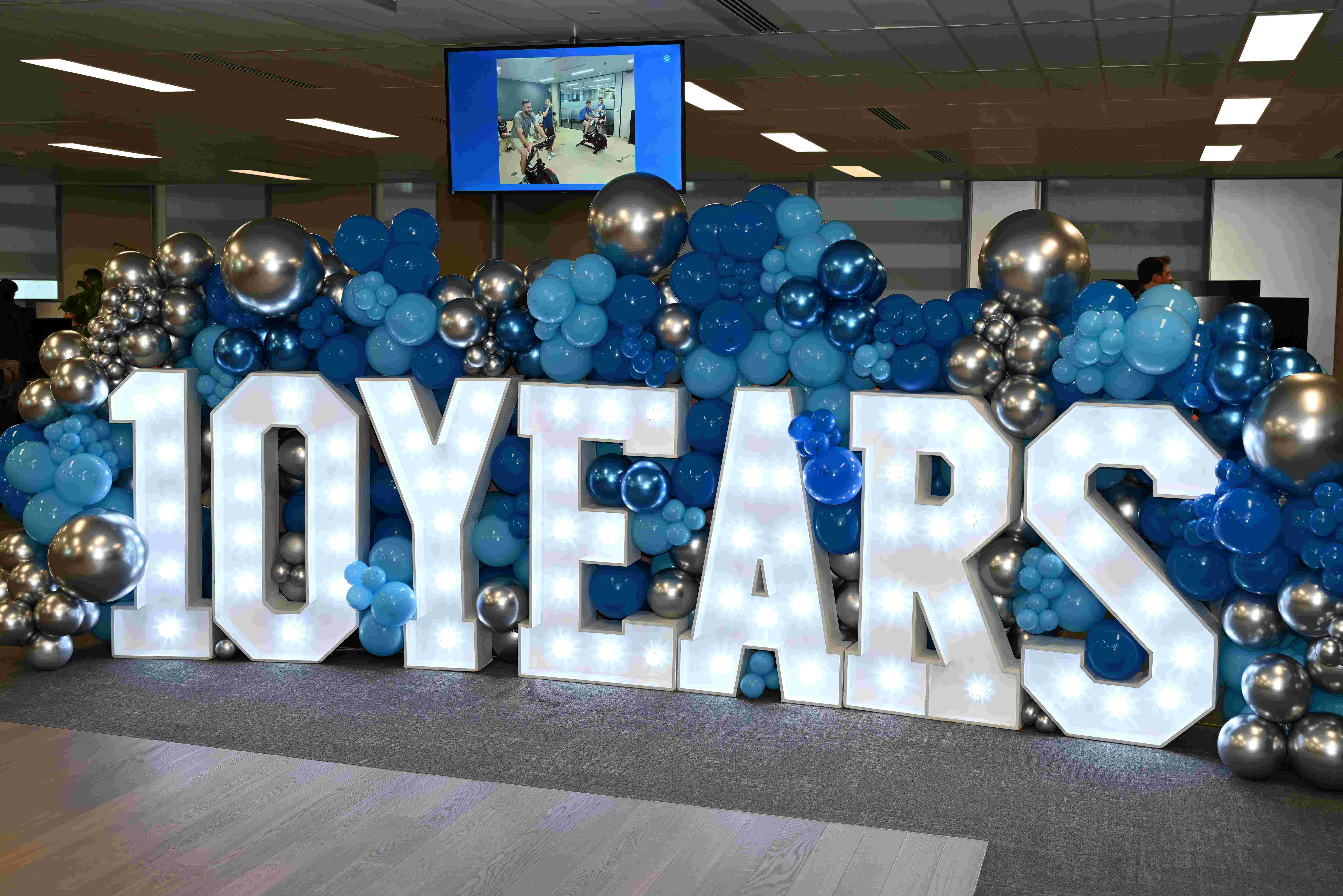 10 years light up letters surrounded by balloons in the Brook Green Supply office 