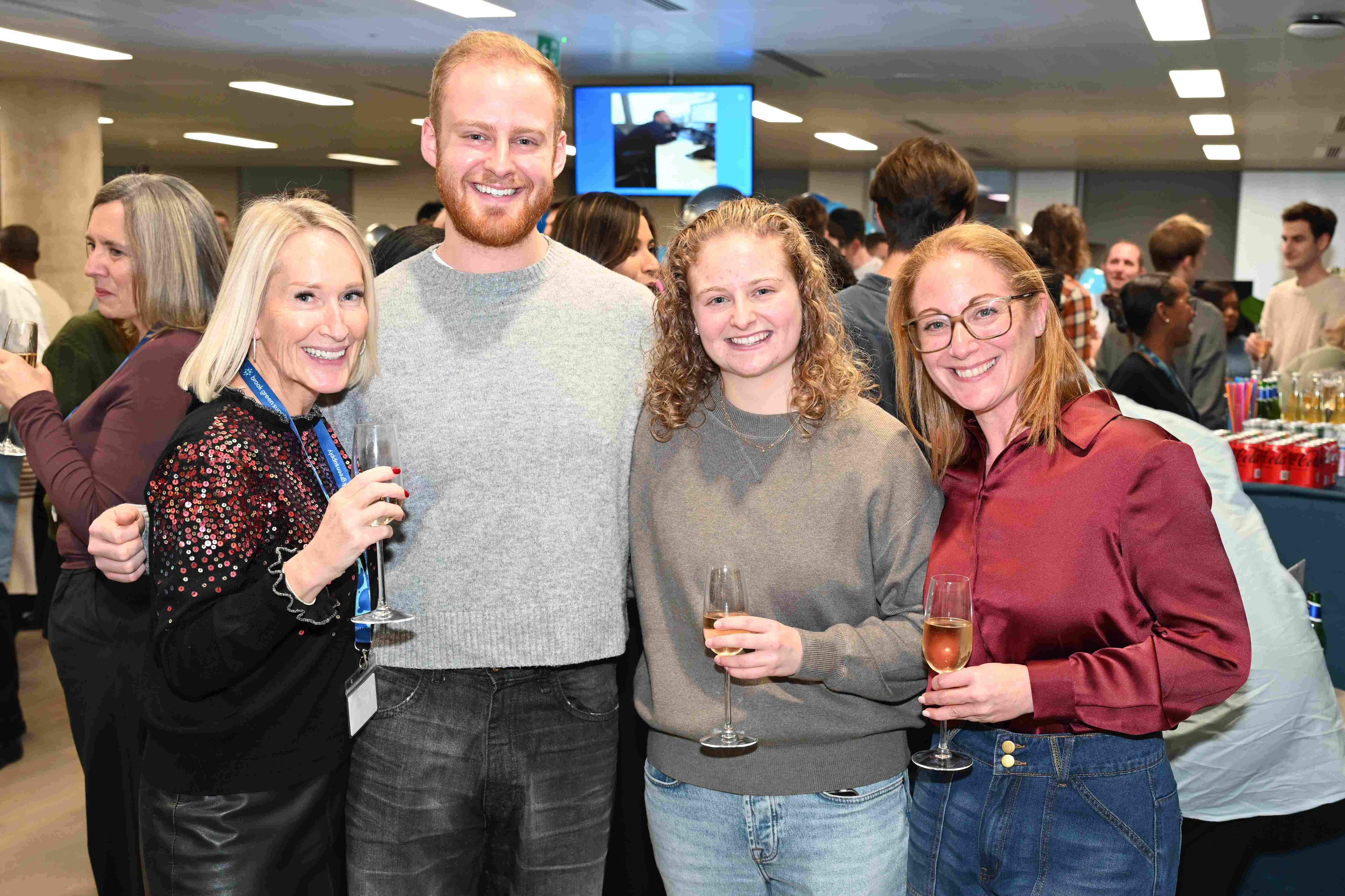 Four people stand for the camera and smile