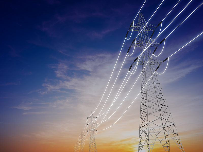 A row of electricity pylons against a sky at dusk, linked by glowing wires.