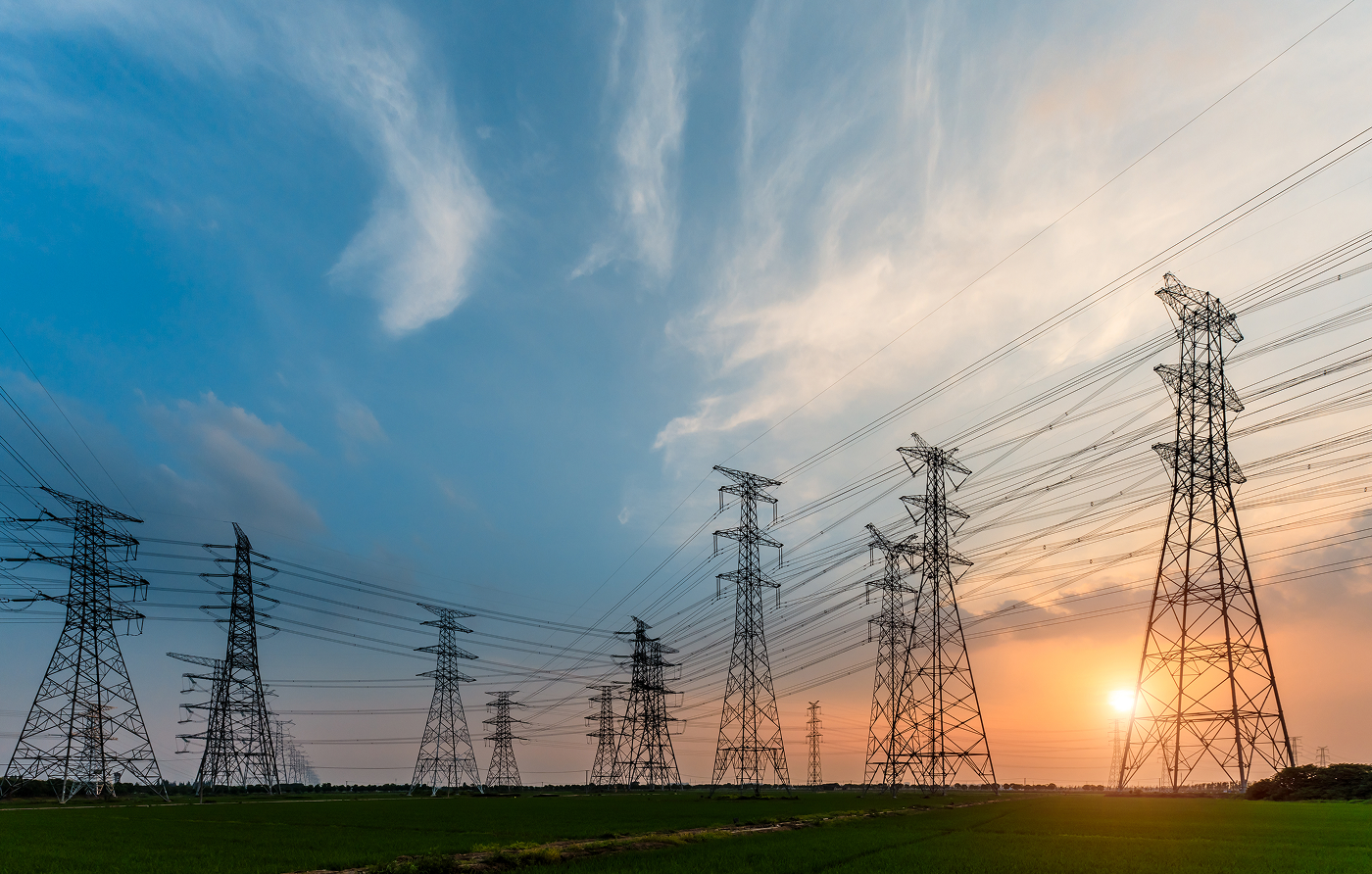 A view from below of an electricity pylon set against a clear blue sky.